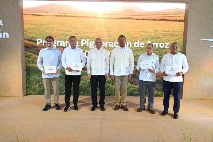 El presidente ejecutivo de Banreservas, doctor Leonardo Aguilera; y el vicepresidente ejecutivo senior de Negocios, Ysidro García, realizan la entrega simbólica del cheque de financiamiento a productores de arroz en el lanzamiento del Programa Pignoración 2026-2027.